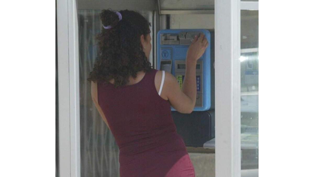 Una mujer llamando por teléfono en una de las cabinas telefónicas de León.