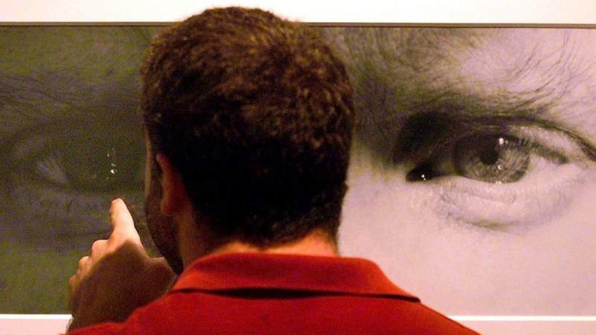 Un hombre observa un autorretrato de Mapplethorpe en una exposición