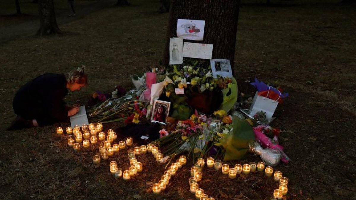 Una muchacha escribe un mensaje de condolencias en el altar montado a las puertas de la mezquita Al Noor, en Christchurch.