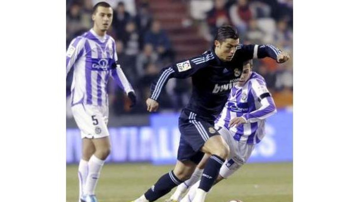Cristiano Ronaldo, autor del primer gol del Madrid, intenta escaparse de un defensor.