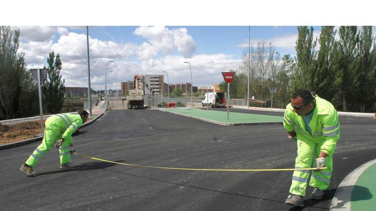 Trabajadores de la obra del puente de La Lastra apuran los últimos retoques.