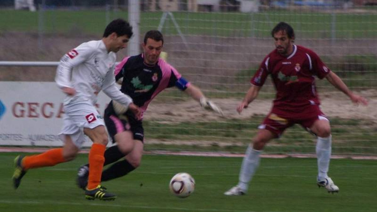 El jugador del Íscar Quique trata de burlar al portero de la Cultural Diego Calzado y al defensa central Prendes en un lance del encuentro disputado en el campo de San Miguel.