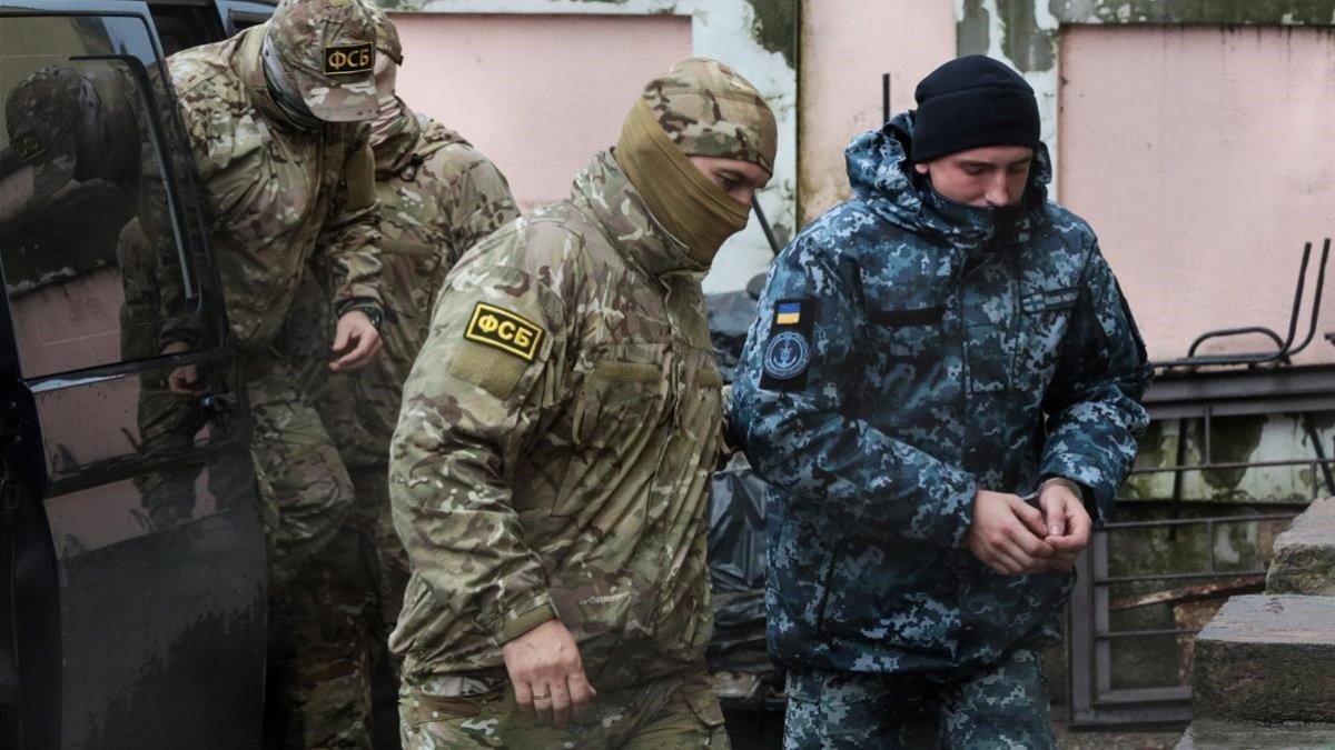 Militar ruso conduce a uno de los marineros detenidos