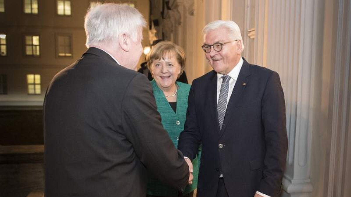 El líder de la CSU, Seehofer, saluda al presidente, Steinmeier, en presencia de Merkel. GUIDO BERGMANN