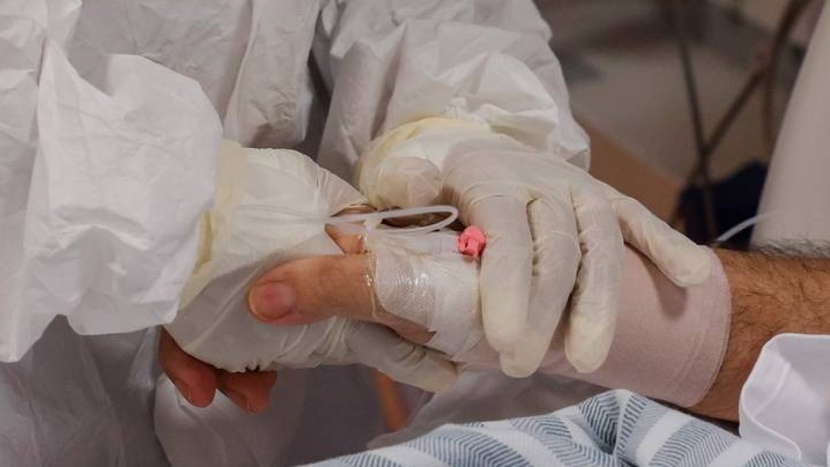 Enfermo de covid es atendido por un sanitario. GIUSEPPE LAMI