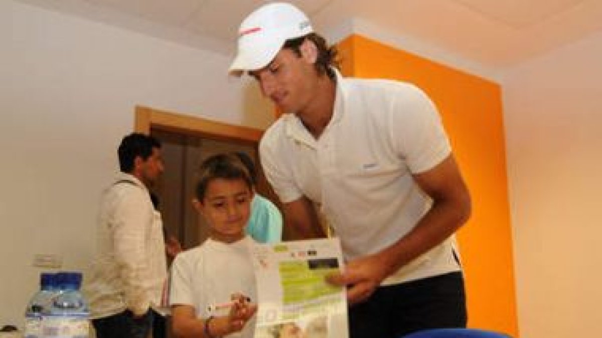Feliciano firma un autógrafo a un admirador, el hijo del árbitro de baloncesto Bultó.