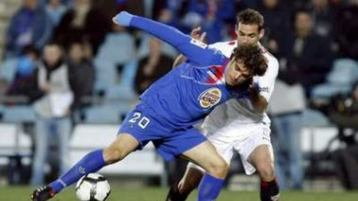 Pedro León, izquierda, protege el balón ante Navarro.