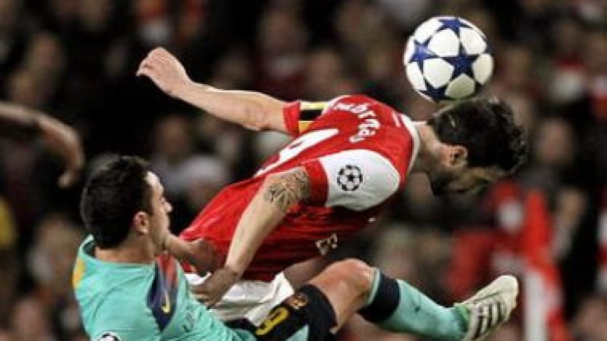 El azulgrana Xavi disputa el balón con Cesc Fábregas del Arsenal, durante el partido de ayer.