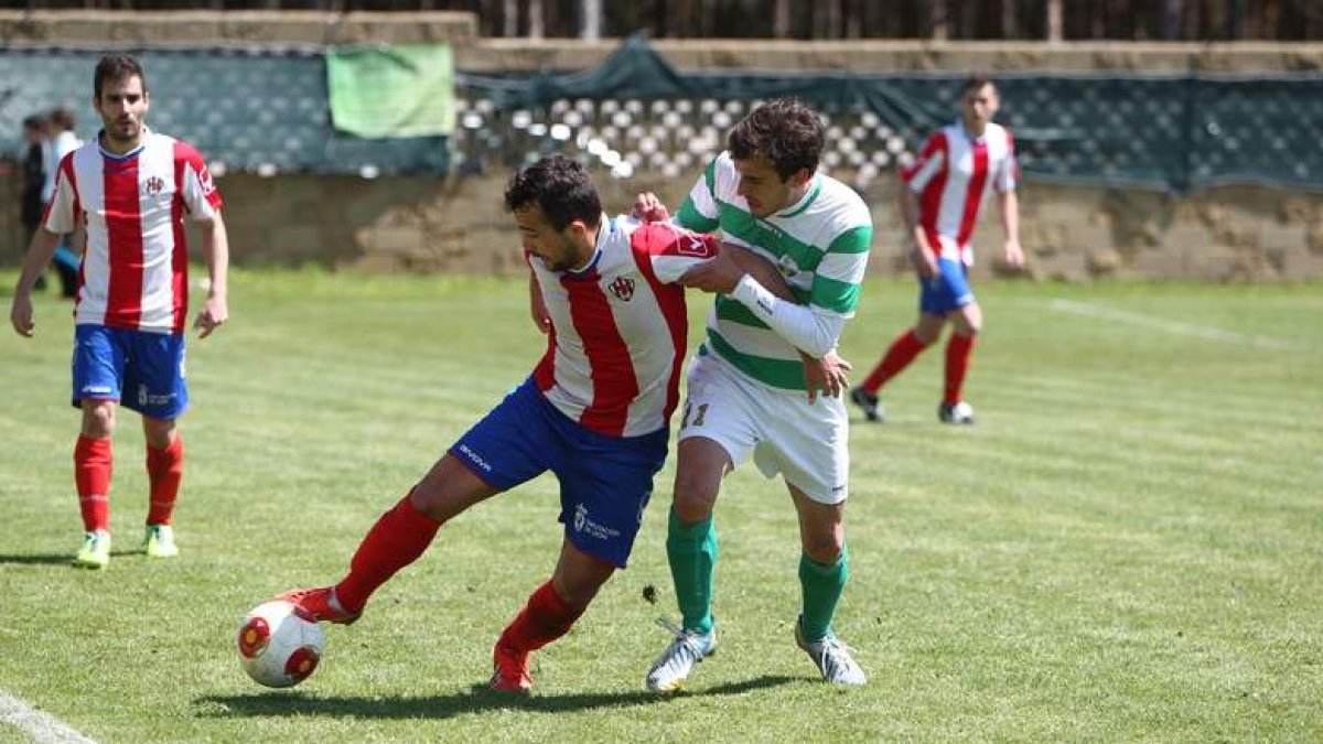 Esaú, a la derecha, trata de cortar el avance de un jugador rojiblanco