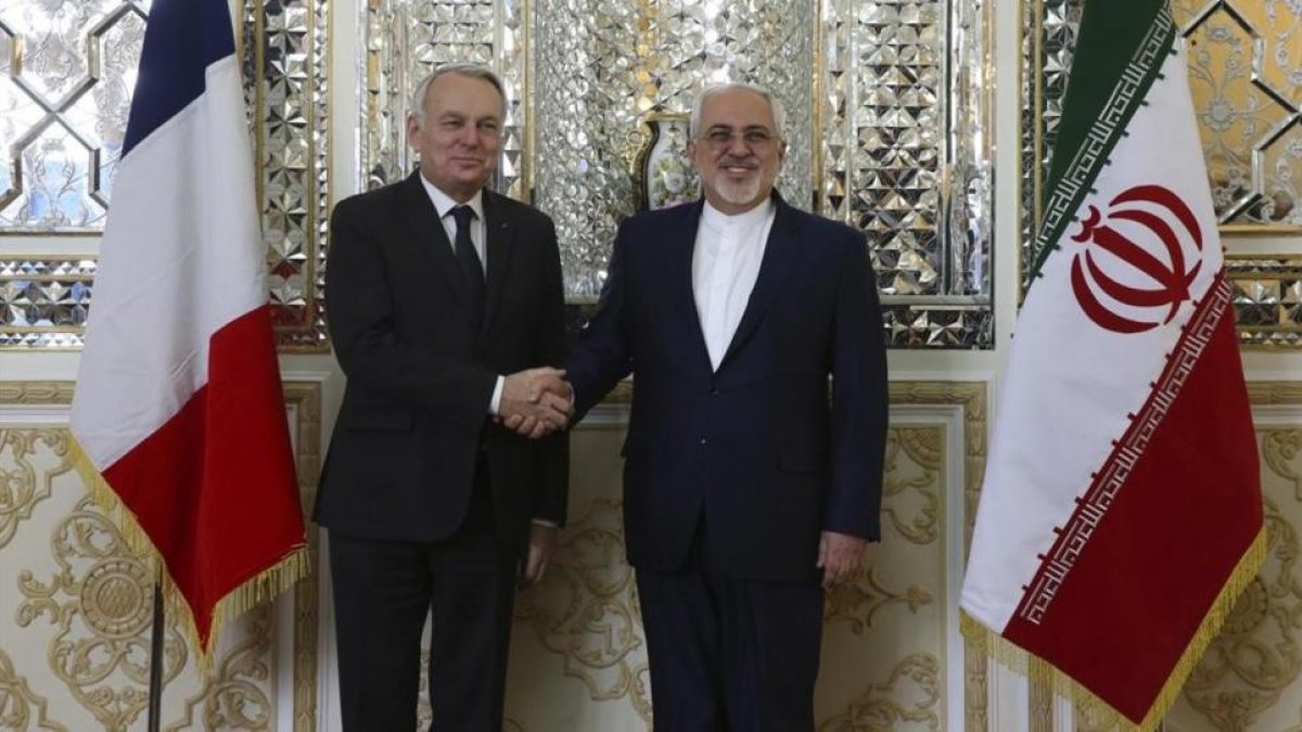 Zarif (derecha) estrecha la mano de su homólogo francés, Jean-Marc Ayrault, antes de su encuentro en Teherán, este martes.