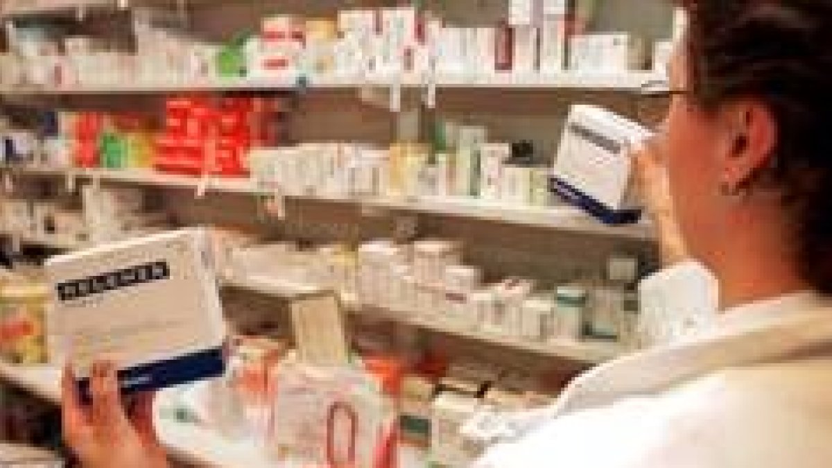 Una farmaceútica sostiene una caja de un medicamento antigripal
