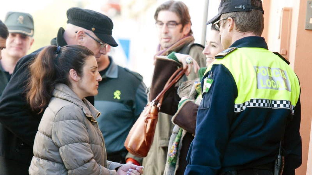 La acusada entra en su casa, acompañada por la policía.