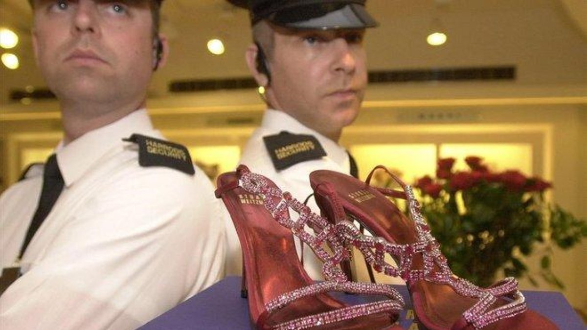 Guardias de seguridad custodian unos zapatos con rubís y platino valorados en 1,47 millones de euros, en Harrods.