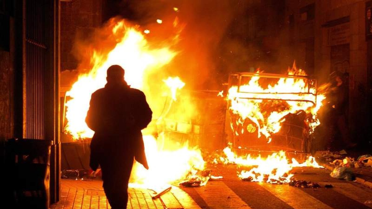 Un hombre corre durante una protesta en el barrio barcelonés de El Raval. ANDREU DALMAU