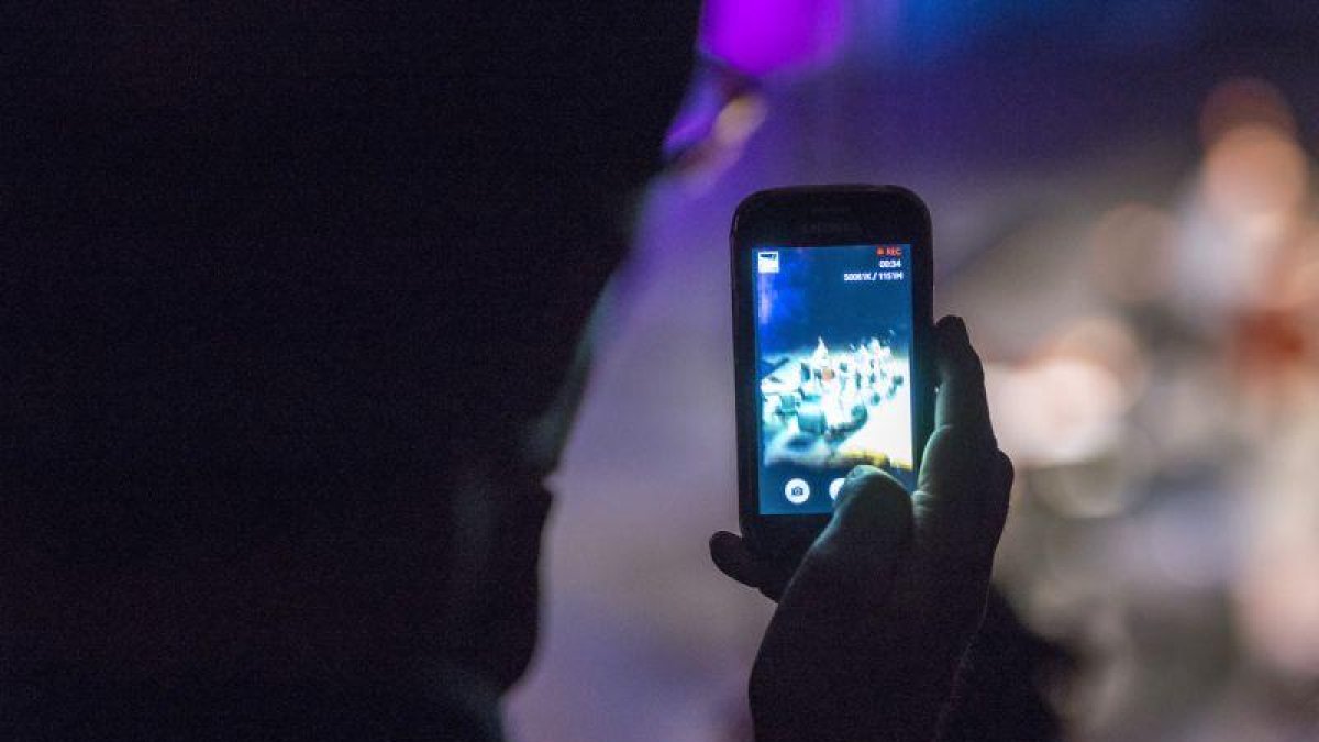 Un usuario utilizando su teléfono móvil durante la noche.