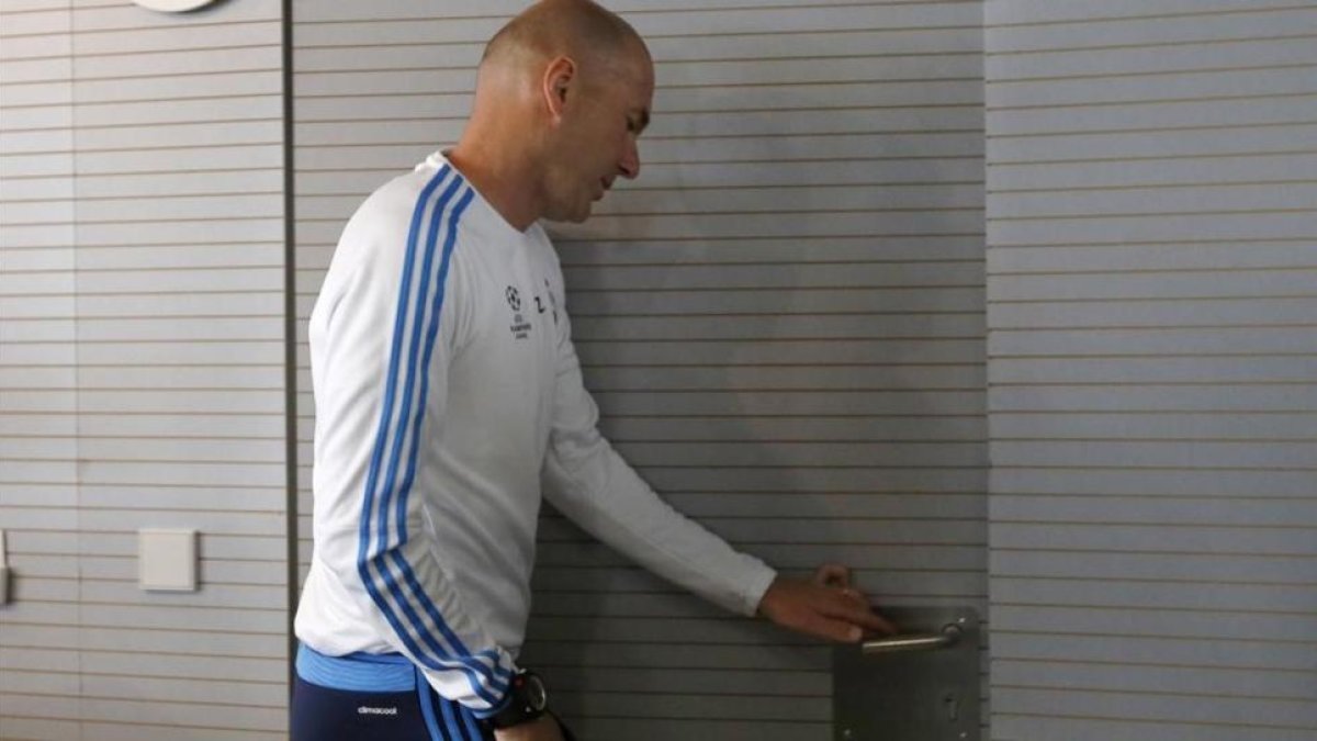 Zinedine Zidane abandona la sala de prensa de Valdebebas tras su comparecencia ante los periodistas.