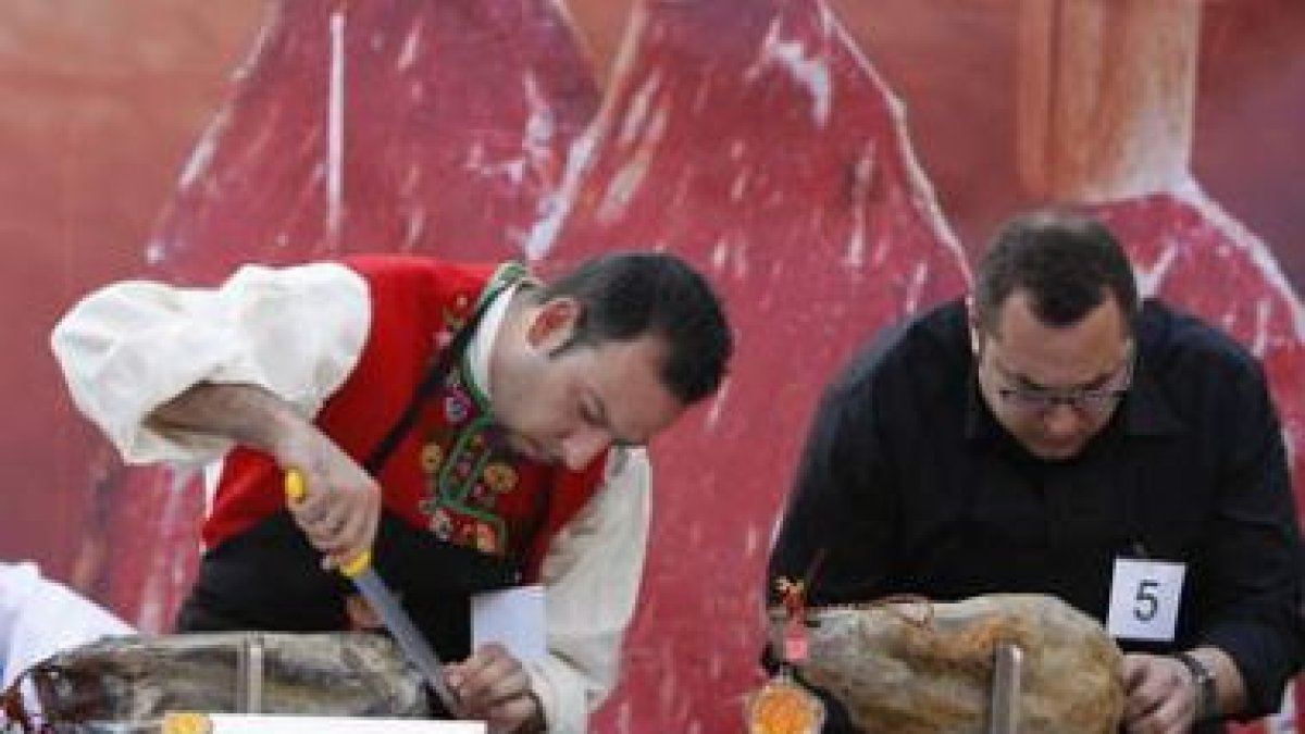 Cortadores de cecina se afanan en su labor durante un concurso celebrado en León.