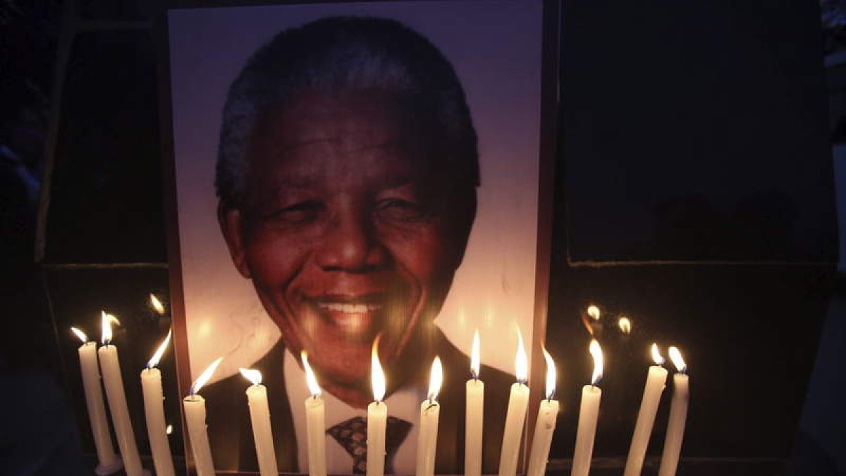 Varias velas lucen junto a un retrato de Mandela, durante una marcha celebrada con motivo del Día Internacional de los Derechos Humanos.
