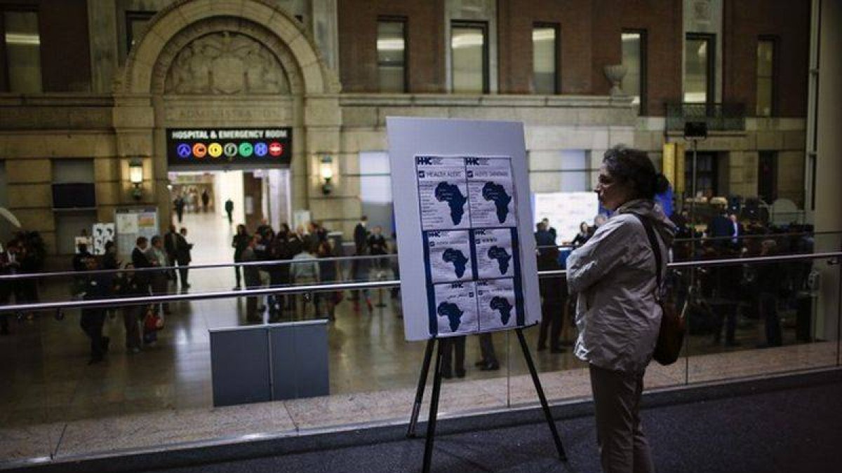 Una mujer ante un cartel con información sobre el ébola en el Hospital Bellevue de Nueva York donde está incresado el doctor Craig Spencer.
