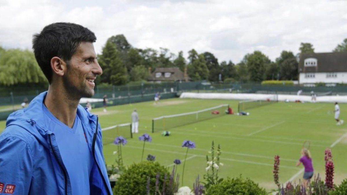 Djokovic observa las pistas de Wimbledon tras el entrenamiento del domingo.