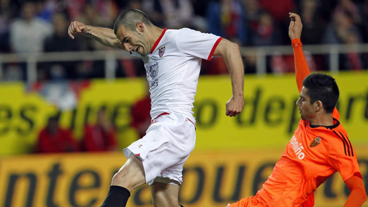 El sevillista Negredo intenta llevarse el balón ante Mateos.