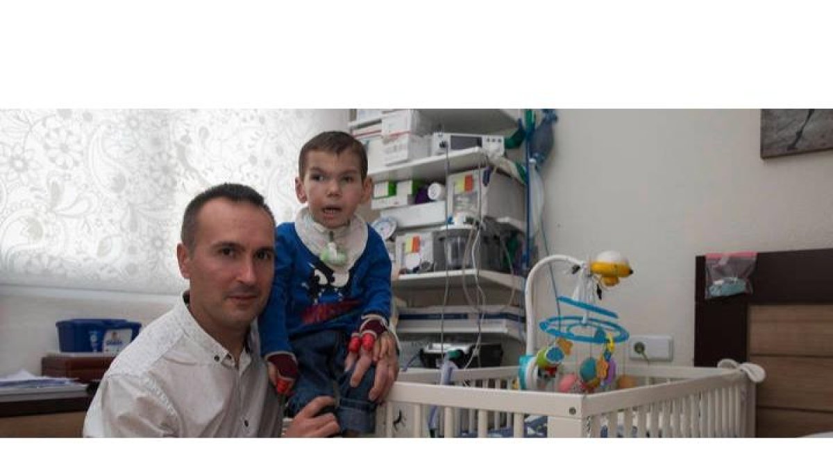 Ricardo Fernández posa con su hijo Marco en la habitación medicalizada que le mantenía con vida, en febrero de este año. FERNANDO OTERO