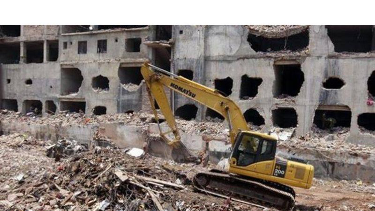 Una grúa limpia los escombros del edificio derrumbado en Savar, en la periferia de Dacca, este lunes.