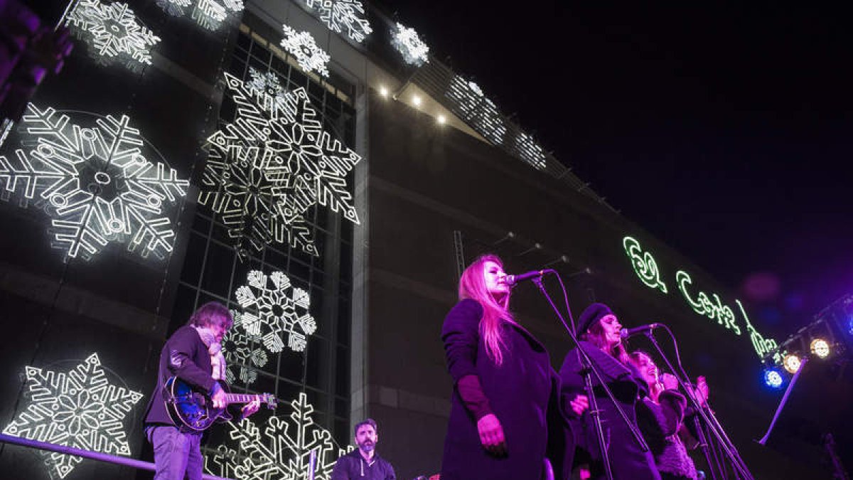 El grupo Good-Man durante su actuación ayer delante de la fachada navideña del centro comercial. FERNANDO OTERO