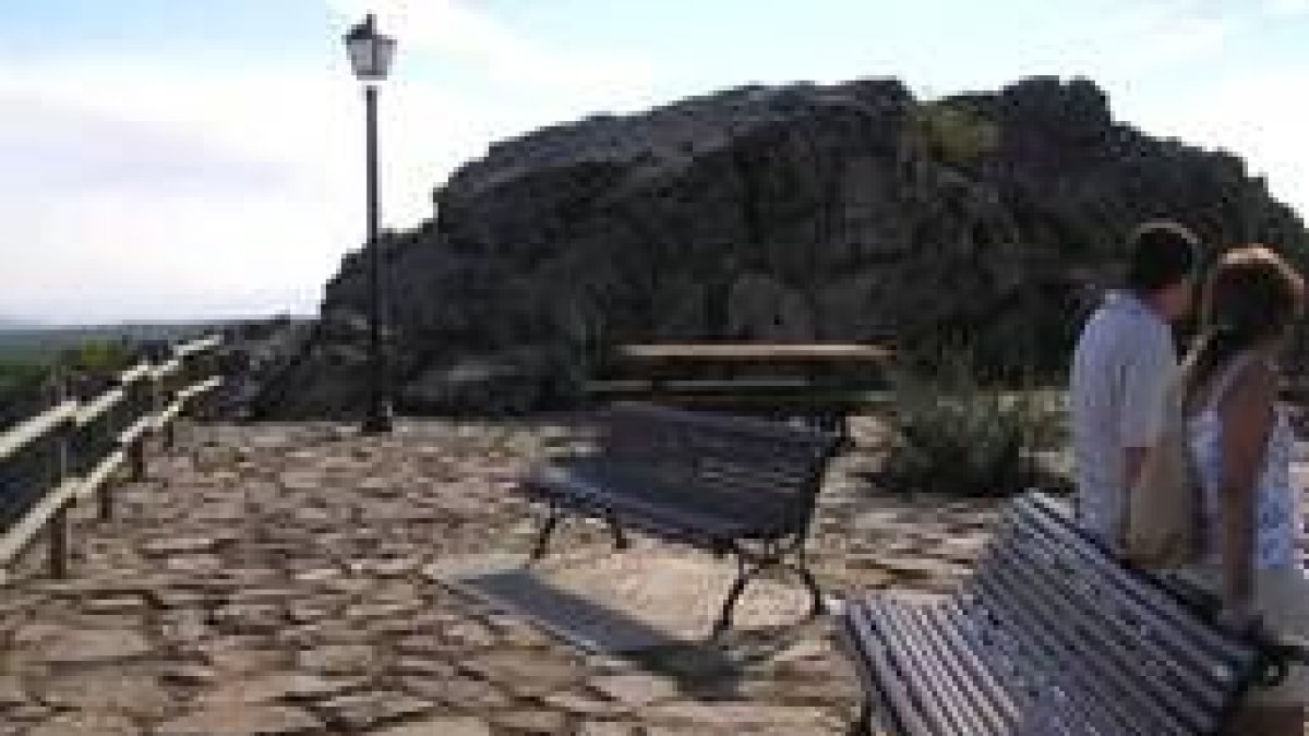 Dos personas reposan al aire libre en el mirador de San Feliz de las Lavanderas una vez restaurado