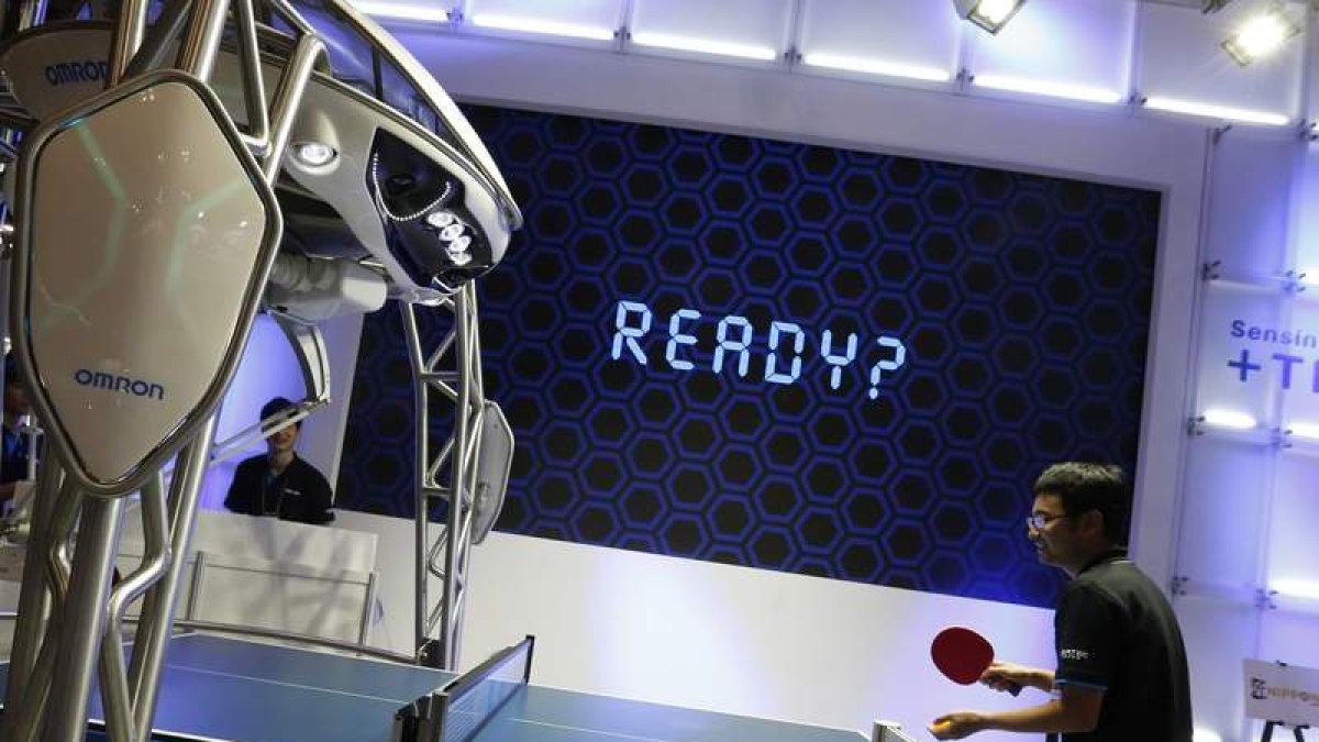 Un hombre juega con el primer robot instructor de tenis de mesa del mundo en Chiba, Japón. YUYA SHINO