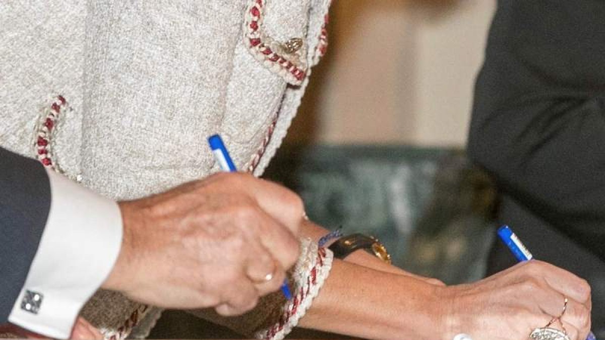 Dos personas firman papeles oficiales. JAVIER CEBOLLADA
