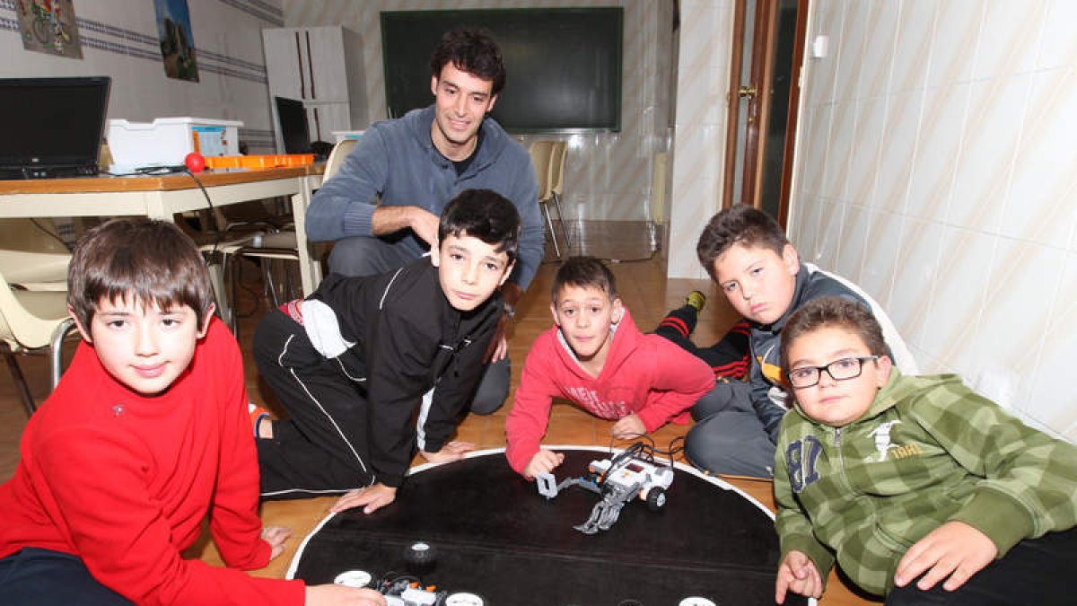 Los alumnos del colegio Virgen del Camino prueban con su profesor, Jorge Pérez, los robots que han construido.
