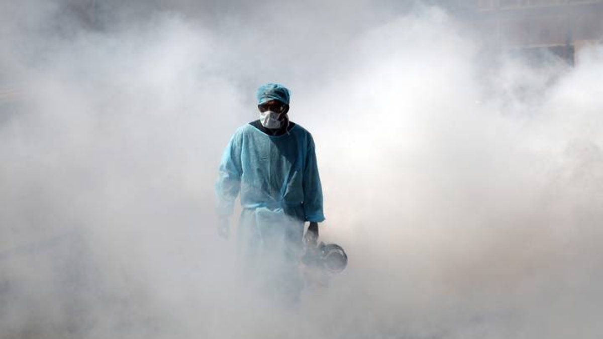 Un trabajador de salud de la Corporación Municipal de Jammu (India) rocía desinfectante en una calle. JAIPAL SINGH