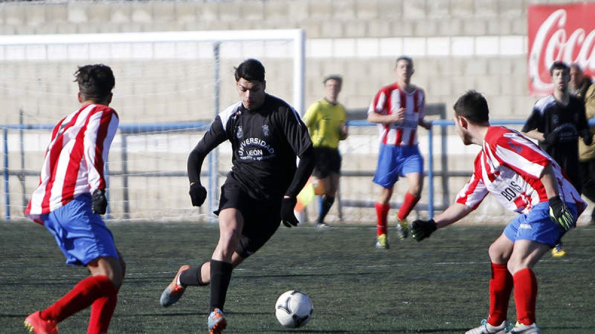 Germán, en el centro, se lleva el balón entre dos contarios.