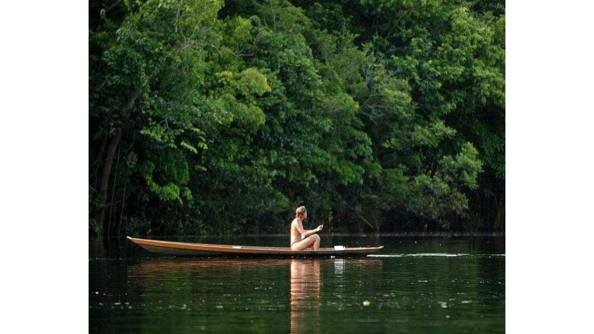 Una turista viaja en una canoa en uno de los afluentes del Amazonas. MARCELO SAY