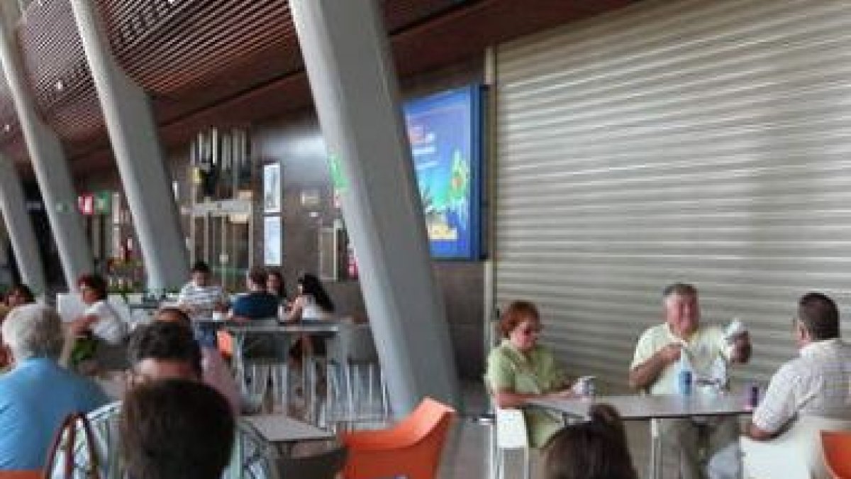 Los viajeros ocupan las mesas dispuestas a lo largo de la terminal.