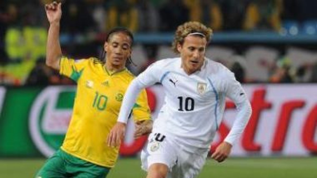 Forlán corre perseguido por el sudafricano Pienaar.