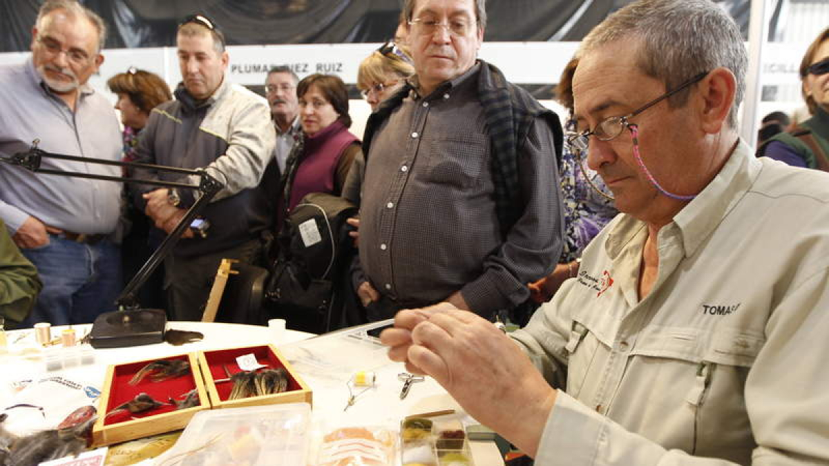 Un artesano hace una demostración en directo del montaje de una pluma.