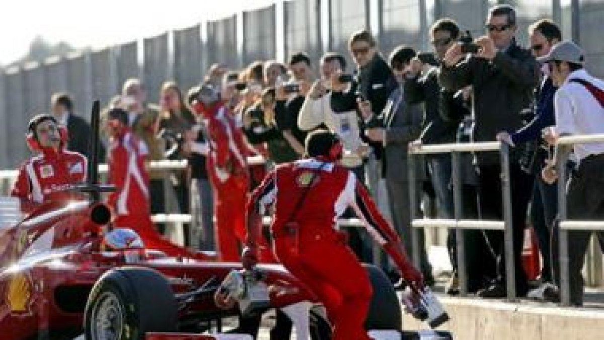 Fernando Alonso y su bólido, rodeados de aficionados en el «pit lane» de Cheste.
