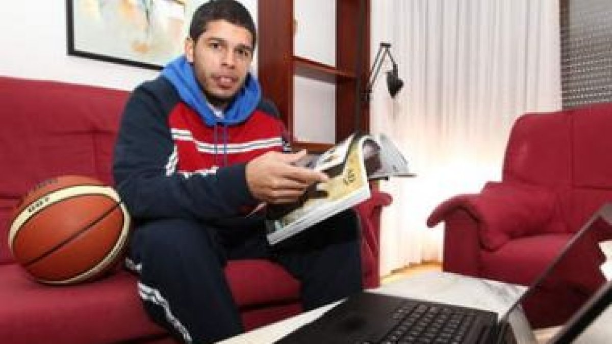 Manny Quezada ojea una revista en su casa, después del entrenamiento, junto al ordenador y el balón.