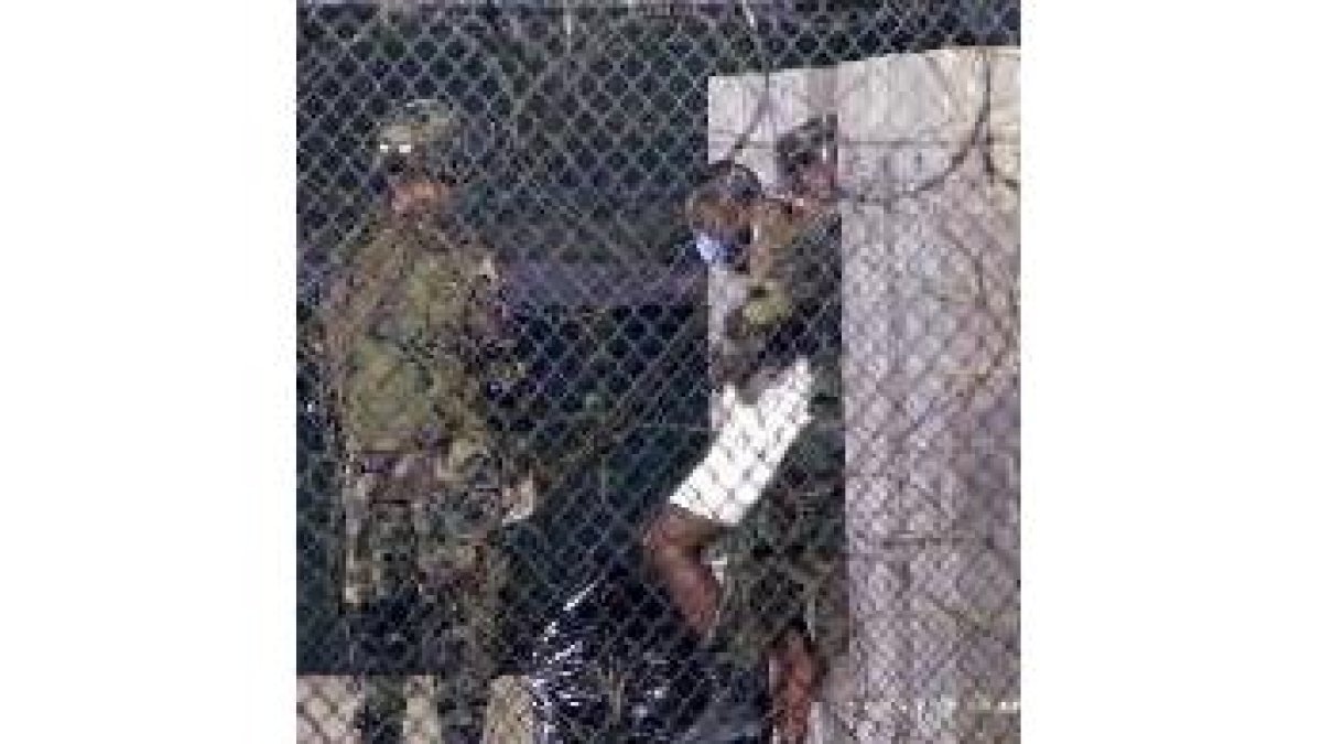 Soldados norteamericanos trasladan a presos recluidos en Guantánamo