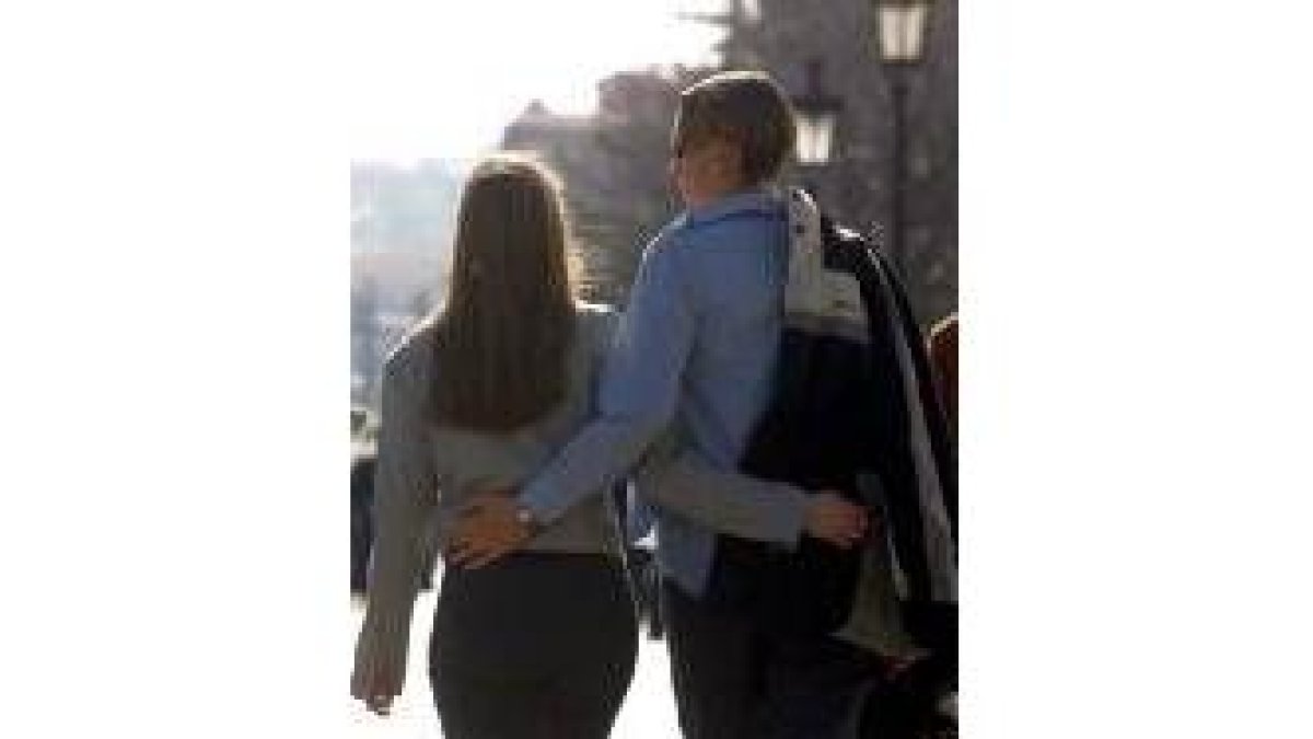 Una pareja camina por una calle de León