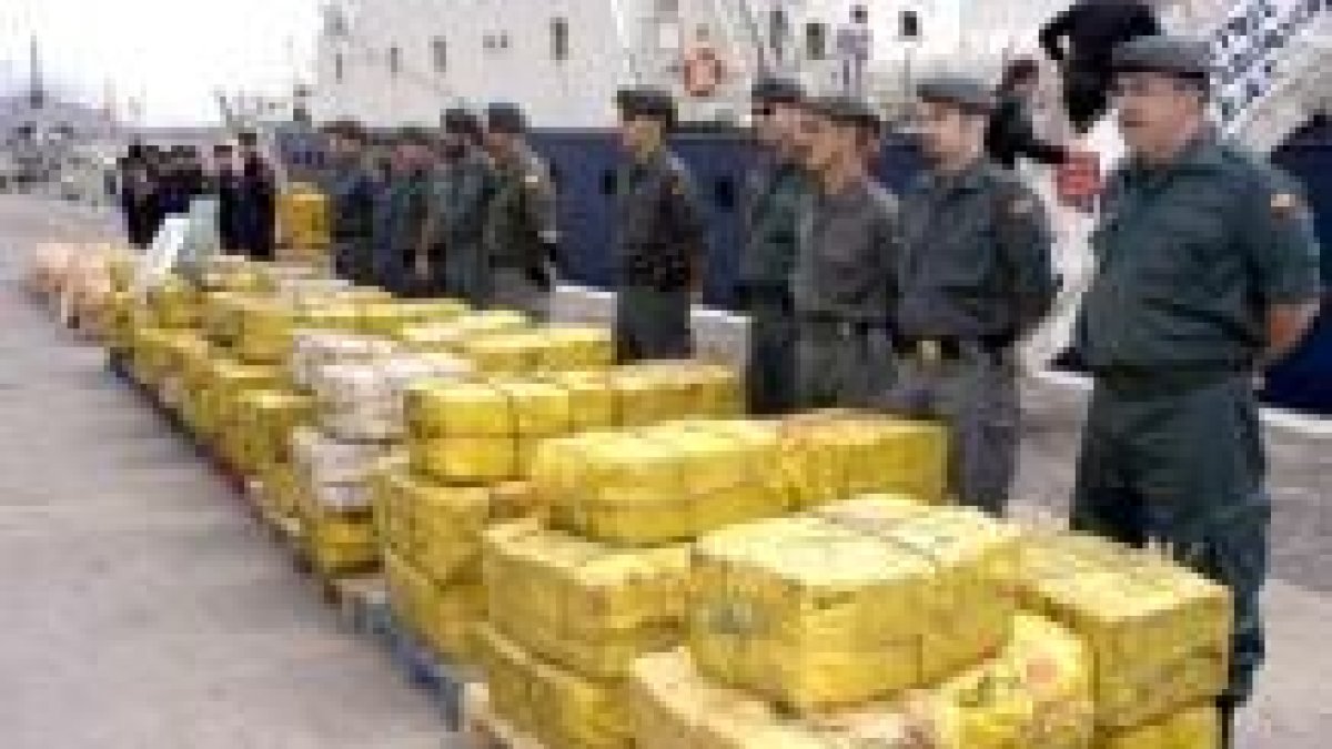 Miembros de la Guardia Civil posan junto a los fardos de cocaína incautada