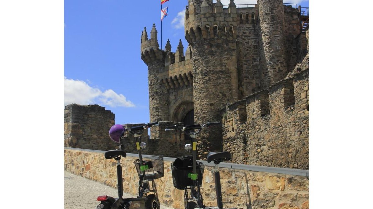 Dos patinetes eléctricos en la fachada principal del Castillo templario de Ponferrada.