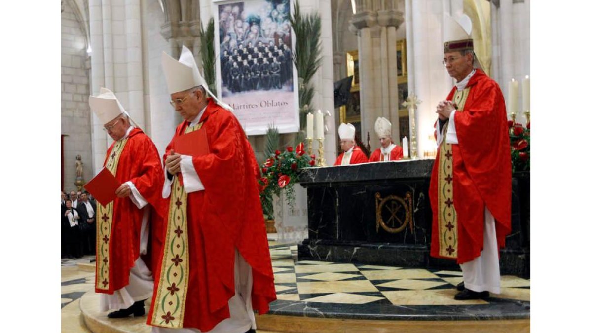 Julian López, obispo de León, seguido del obispo de Astorga, Camilo Lorenzo, con la foto de los misioneros al fondo.
