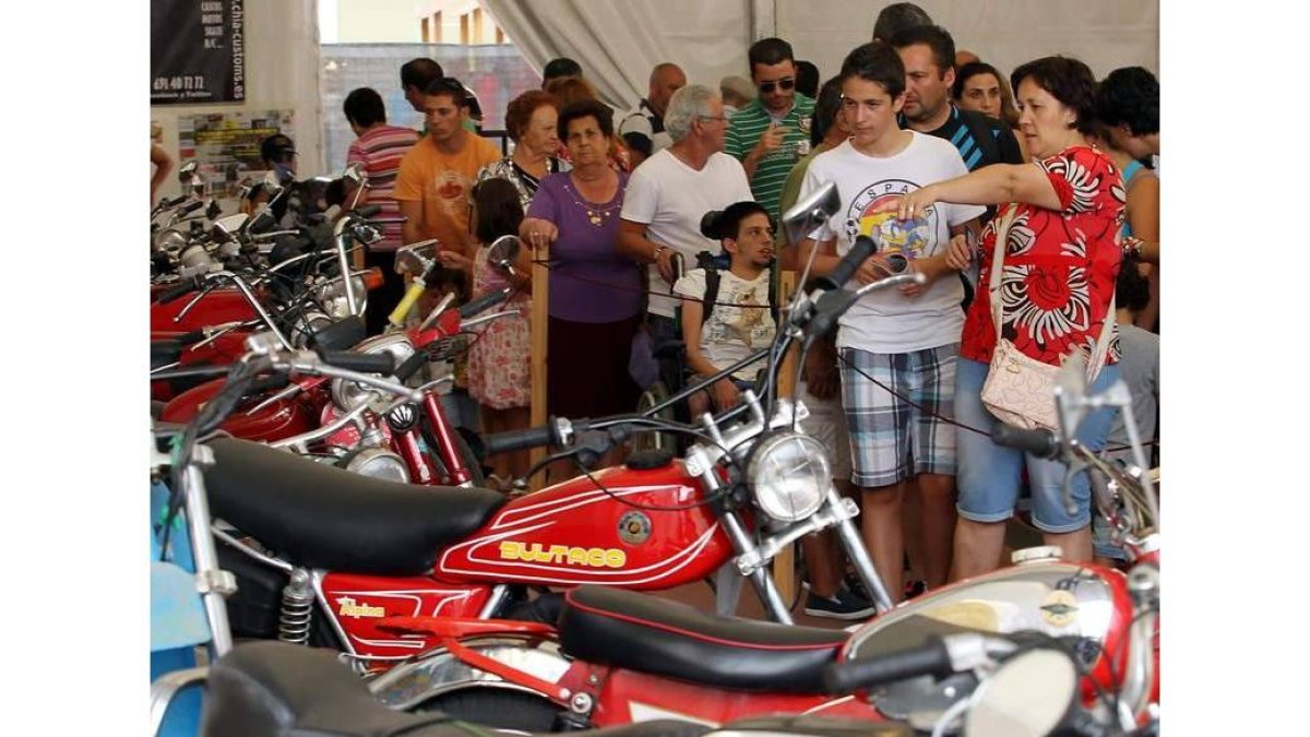 José Miguel Palazuelo observa una antigua Bultaco ante José Luis Falagán y Tomás Gallego.