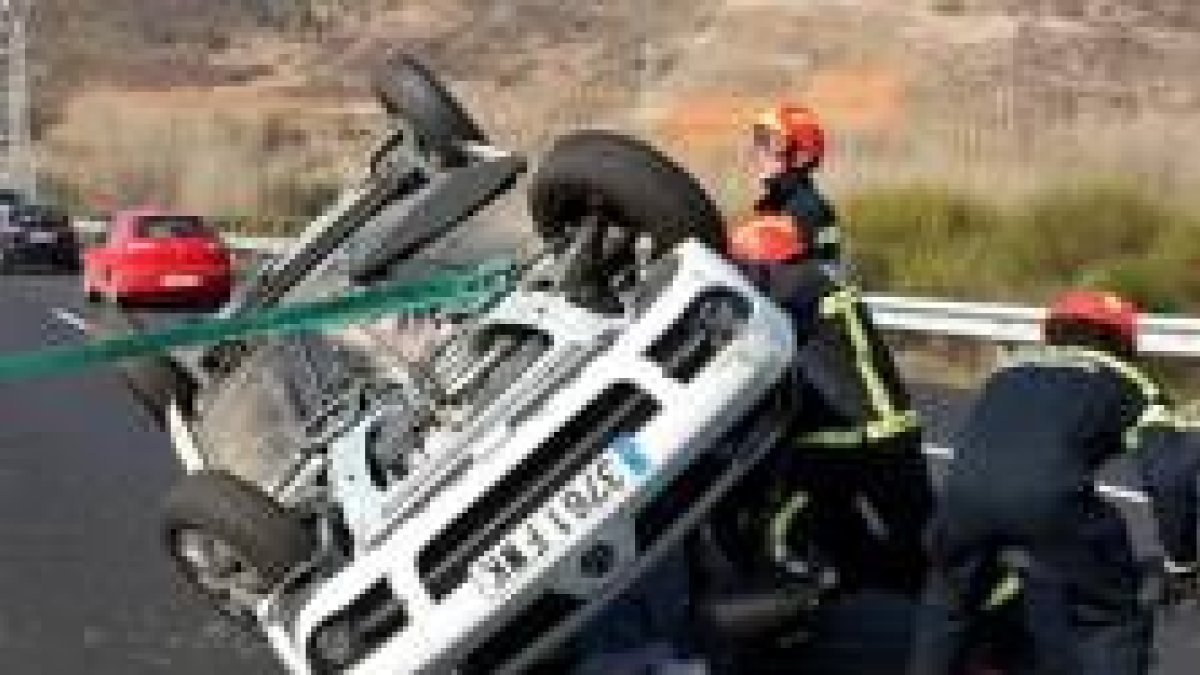 Momento en el que los bomberos retiran el coche de la autovía