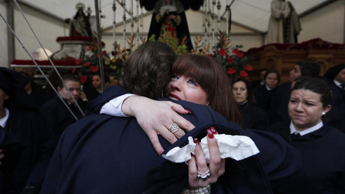 La tradición pasa de padres a hijos en León, que vive y siente estos días como algo muy suyo. En la imagen, dos cofrades del Sacramentado se abrazan tras suspenderse la procesión. JESÚS F. SALVADORES
