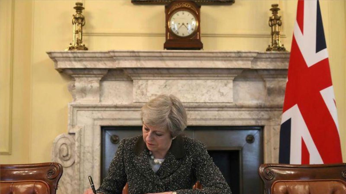 La primera ministra británica, Theresa May, firma la carta con la que arranca el 'brexit'.