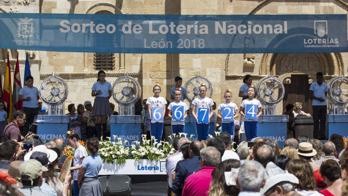 Los niños de San Ildefonso muestran el número agraciado en el sorteo. FERNANDO OTERO